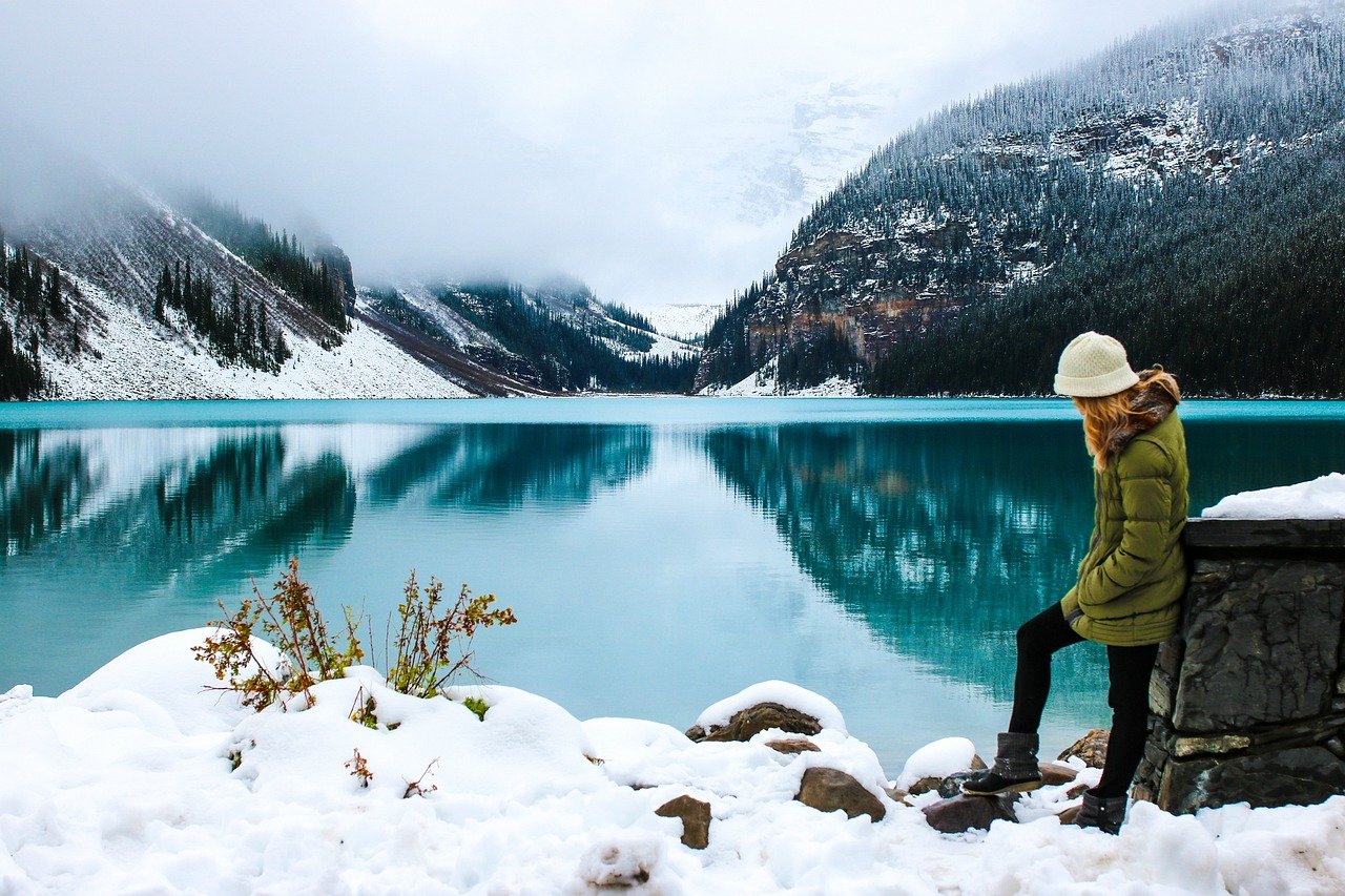 solo woman by lake with mountains